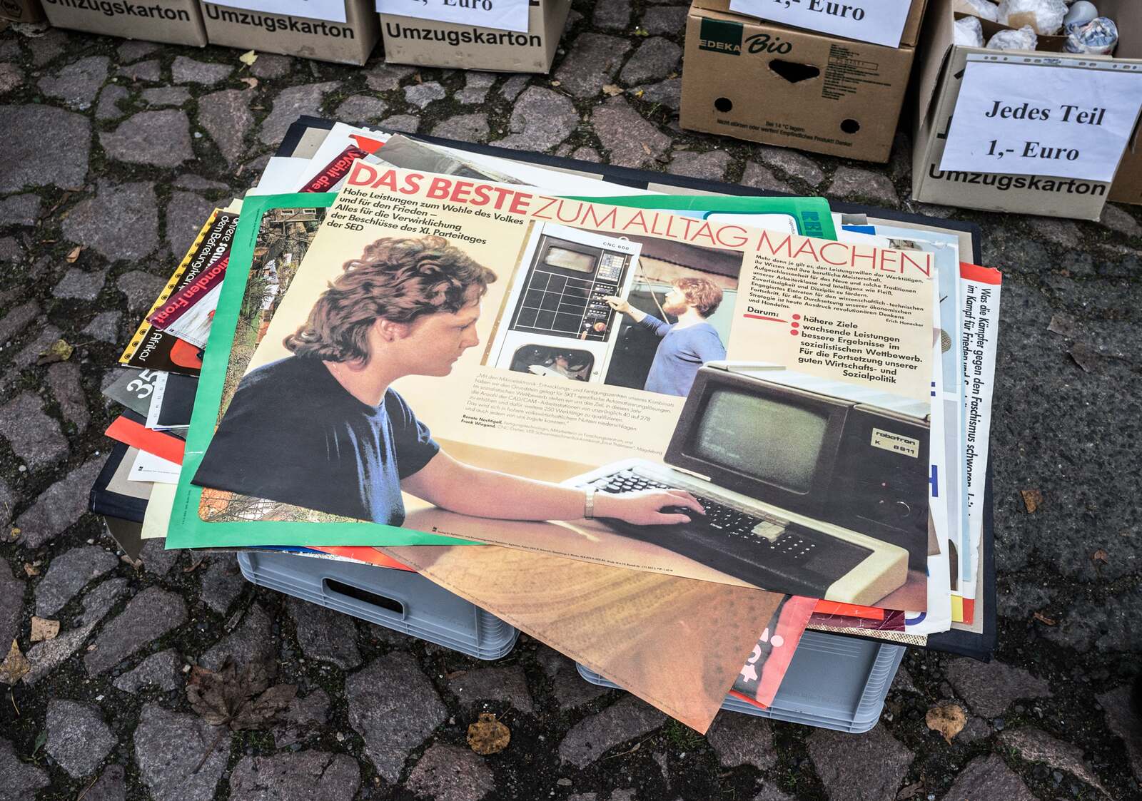 DDR-era posters in a plastic crate — one euro each